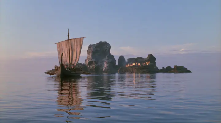 extreme wide shot from behind a long black ancient Greek galley with a single mast, a square sail and two banks of oars on a glassy sea, on the horizon a cluster of black rocks with tiny gold-lit figures of women,…