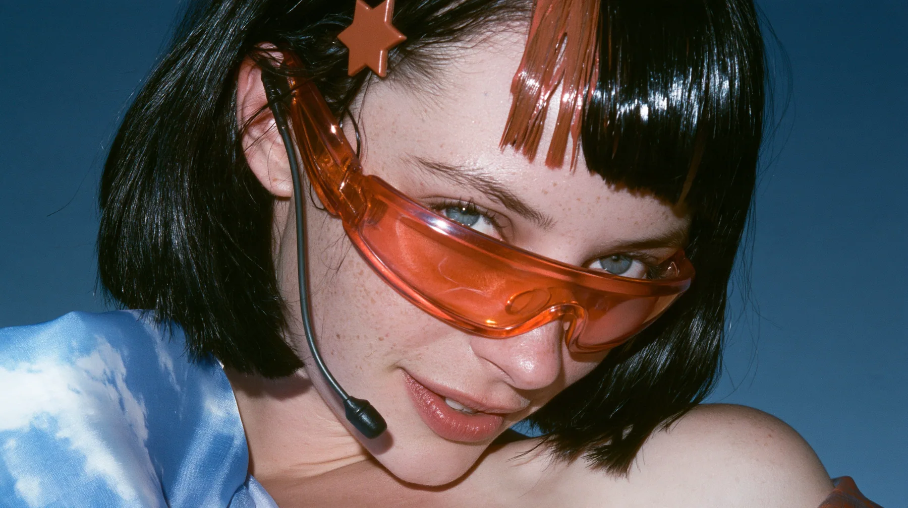 Claudia in BLISS: Y2K high fashion editorial, a 2001 couture magazine story: close-up of a Caucasian American woman in her mid-twenties with pale skin and light freckles, a glossy black blunt jaw-length bob with heavy straight bangs…