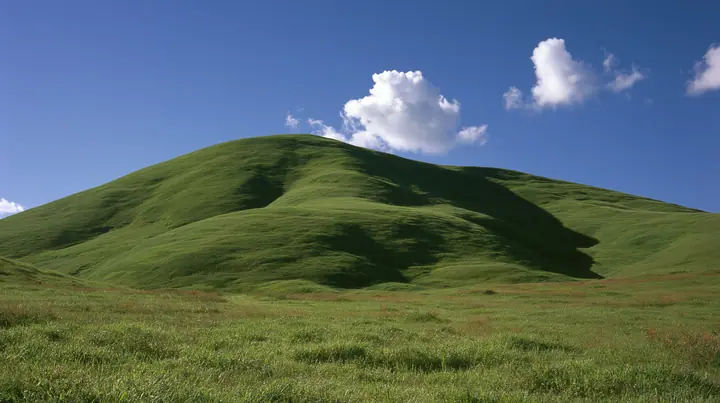 a smooth rolling bright-green grassy hill with soft curves, the grass short and velvety under a deep saturated cobalt-blue sky with a few soft white cumulus clouds drifting, bright midday sun, perfectly clean and…